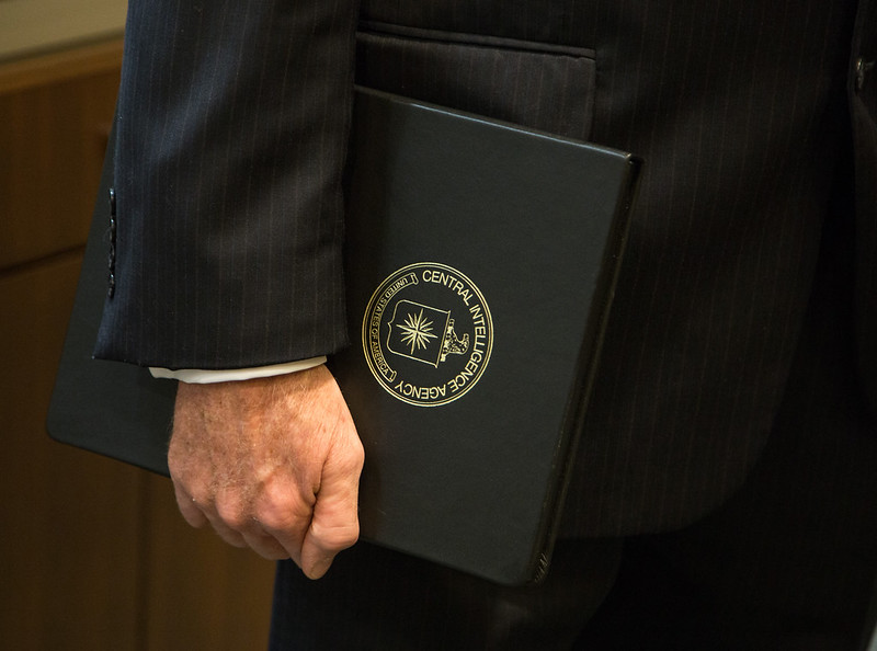 A Faceless Person Carrying a Folder with the CIA Insignia